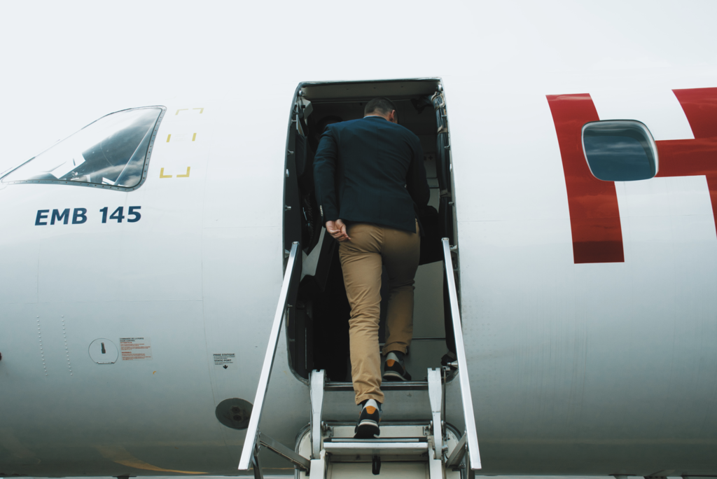 A person climbing stairs to access an airplane