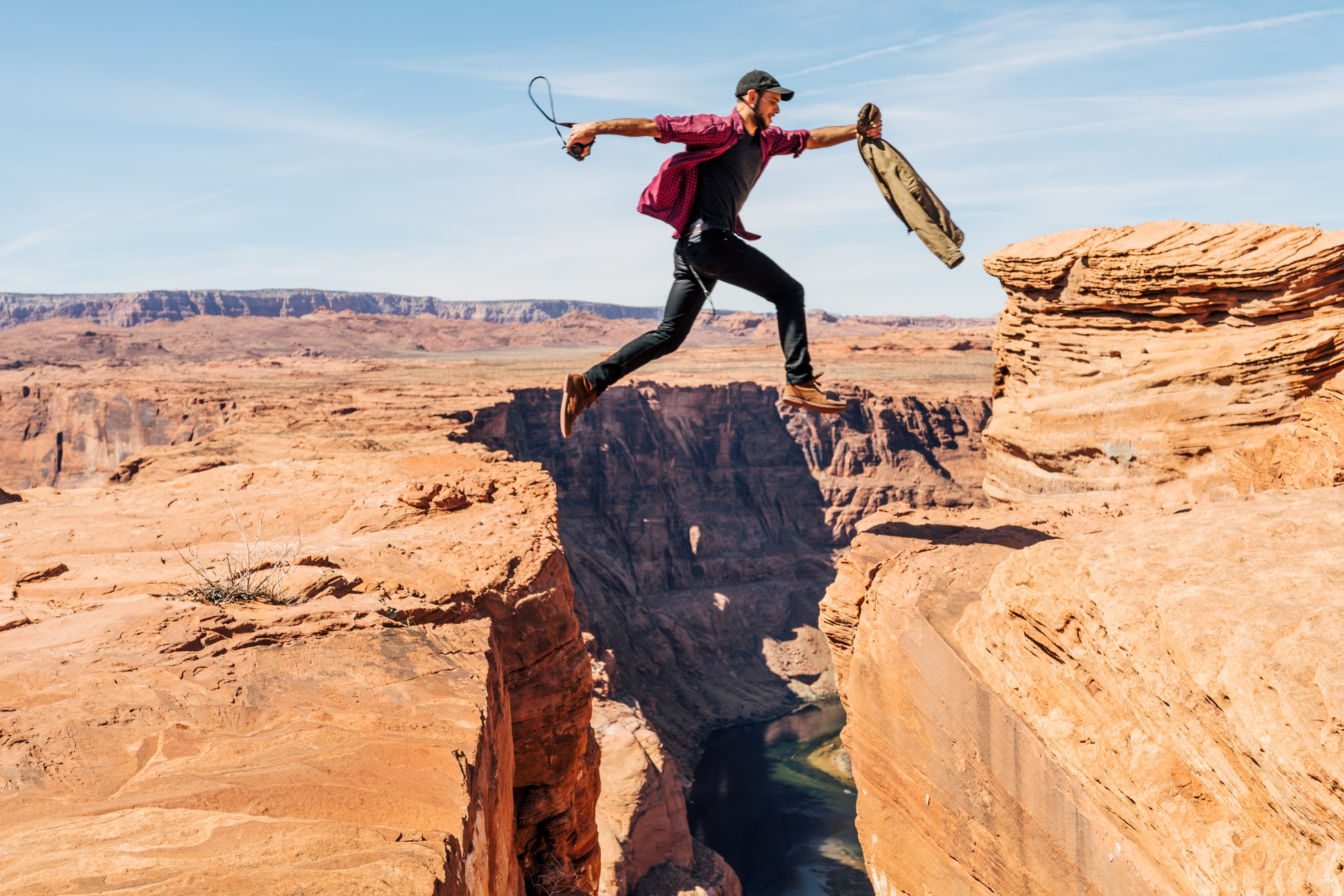 person jumping over a canyon