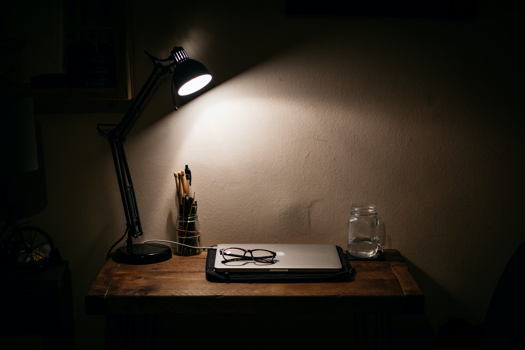 Work tools on a desk lit by a lamp