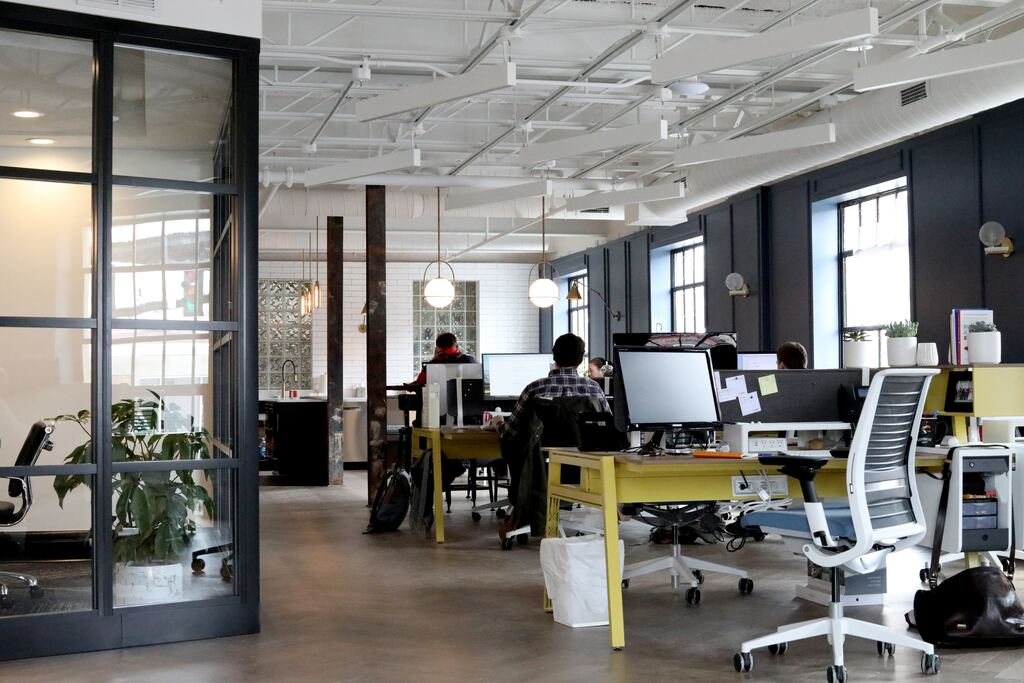 A modern and airy office space where there are several employees